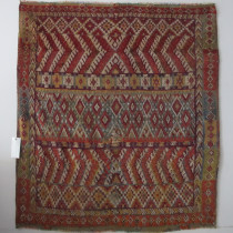 Glaoui Rug - This striking Glaoui rug was woven by the Berbers in the High Atlas Mountains, Morocco. It has wonderfully soft wool, great natural dyes and a riotous design of multiple geometric ornaments, including repeating lozenges, chevrons, and stepped diamonds. The movement of colour and design is kaleidoscopic and mesmerising, holding the viewer's gaze. One can imagine this beauty on the wall in a contemporary setting, or on on a floor adding colour and style. Note also the simple charming borders with their changes of colour, and the little knotted elements added into the kilim ends. The whole composition is delightful and would add much joy to any setting. Professionally cleaned and in good condition. Minor areas of repiling. Image of Glaoui Rug