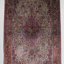 Fine Silk Kashan Rug - This is a lovely Persian silk rug. Finely knotted on a silk foundation, it has a luxurious tactile quality. The design is extremely well drawn, centred by a lozenge anchor medallion with matching spandrels on an ivory field surrounded by rich flora and foliage. The magenta border repeats the theme with palmettes and other floral ornaments. The whole composition is exuberant yet elegant. Cherished through the generations, it has survived in very good condition with very good pile throughout, no stains or damage. The original selvages and ends are intact. This is a superb example of Kashan silk weaving in the early 20th century, a type which is becoming scarcer and scarcer. Image of Fine Silk Kashan Rug