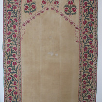 BoKhara Suzani with Architectural Design - This finely worked Bokhara suzani dates to the mid-19th century. However, the design, and in particular the spandrels, reveal the influence of 17th and 18th century Moghul art. As we know, the oasis khanates of Uzbekistan lay on the silk road. Artists and craftsmen of all types were constantly exposed to myriad influences which is so clearly manifested here in this elegant piece. The architectural format and its height also suggests that it was made to cover an entrance or doorway, another device very much associated with Indian decoration. Although the central plain panel has evidently been repaired, the embroidery is in excellent original condition. Lined in a grey cotton, the original ikat trimmings around the edges are intact. Image of BoKhara Suzani with Architectural Design