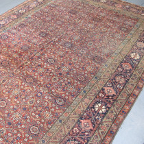 'Old School' Fereghan Kellei - This lovely Fereghan carpet from Central Persia precedes by a generation the Renaissance period of Persian carpet weaving at the end of the 19th century. Finely knotted with a thin pile, the exquisite colouring and refined drawing of the design are a testament to a pre-commercial weaving tradition. Furthermore, the kellei format seen here, highly popular in Persian homes, suggests that this piece may well have been made for a domestic client. The field design of repeating stylised floral ornaments on a subtle terracotta background is both complex and elegant, while the more spacious palmette main border on a sapphire field provides the perfect frame. Given the great age, this carpet has survived in reasonable condition. Professionally cleaned. Selvages restored. This is a wonderful old carpet which would look great in either a period or contemporary setting. Image of 'Old School' Fereghan Kellei