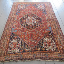 Qashqai Rug - This classic Qashqai rug is woven on a woolen foundation with high quality wool pile and natural dyes. The anchor medallion in the field is centred by a dramatic geometric ornament which is then repeated in the spandrels. The rest of the field is filled with stylised floral ornaments and dramatic horses as seen on the pillars in Persepolis. Note also the colourful chevron ornaments on the sides of the field. All this is framed by classic stylised floral borders. It's a delightful composition, full of tribal character. The colours are delicious, especially a very lovely apricot and light blue. Used carefully over the generations, it has survived in generally good condition with only minor signs of wear. The ends and selvages are intact. Professionally cleaned in my workshop. Image of Qashqai Rug