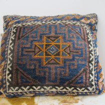 Belouch Bag - Recently used as a cushion, this Belouch bag has very good soft wool and an interesting design. The burnt-orange central eight-pointed star appears to be floating above a decorative fretwork field of aubergine and sapphire blue. Its a very unusual and striking composition. The inner guard stripe with the reciprocal border and the wider main border provide a perfect frame. The original back is intact. Dating to the early 20th century this lovely piece has survived in very good condition with a soft velvety pile. Image of Belouch Bag